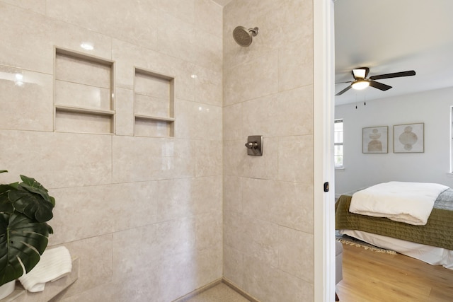 bathroom featuring wood-type flooring, tiled shower, and ceiling fan