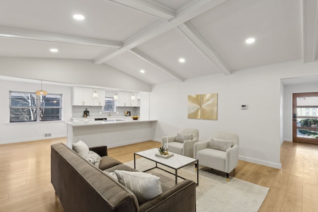 living room featuring light hardwood / wood-style floors and lofted ceiling with beams