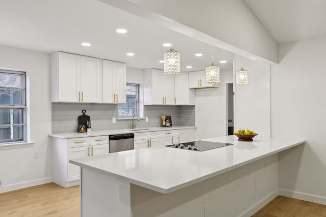 kitchen featuring white cabinetry, stainless steel dishwasher, black electric cooktop, sink, and pendant lighting