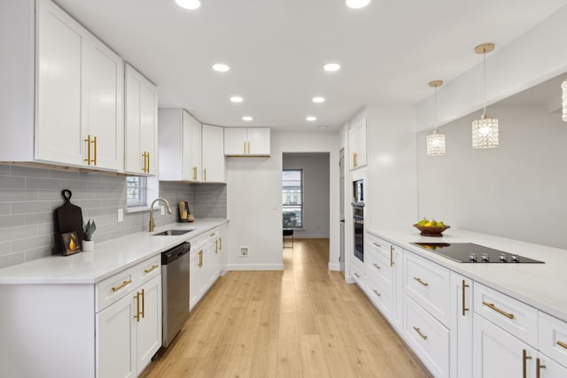 kitchen featuring pendant lighting, sink, white cabinetry, and dishwasher