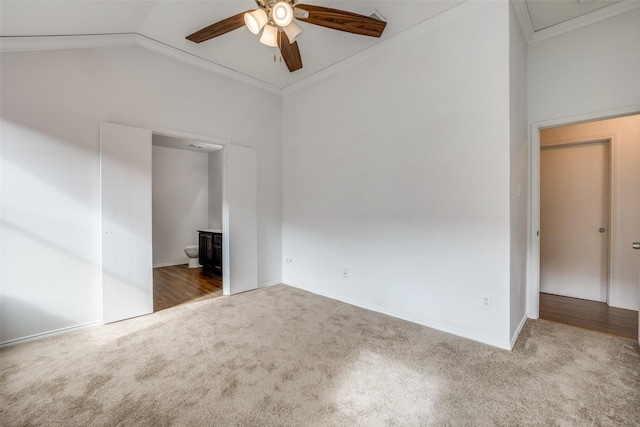 unfurnished bedroom featuring carpet floors, connected bathroom, lofted ceiling, and ornamental molding