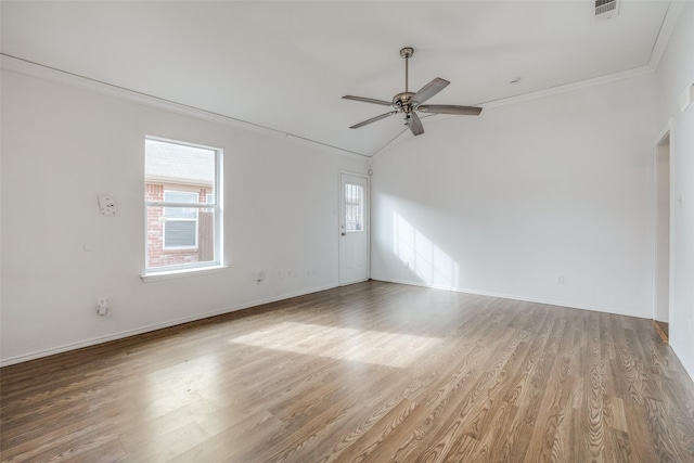 empty room with hardwood / wood-style flooring, ceiling fan, ornamental molding, and lofted ceiling