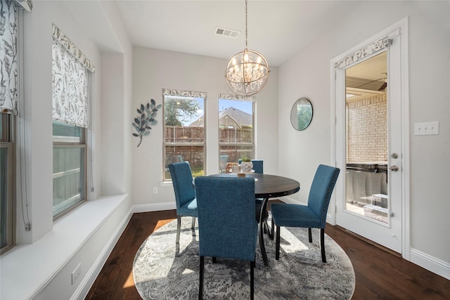 dining area featuring visible vents, dark wood finished floors, baseboards, and an inviting chandelier