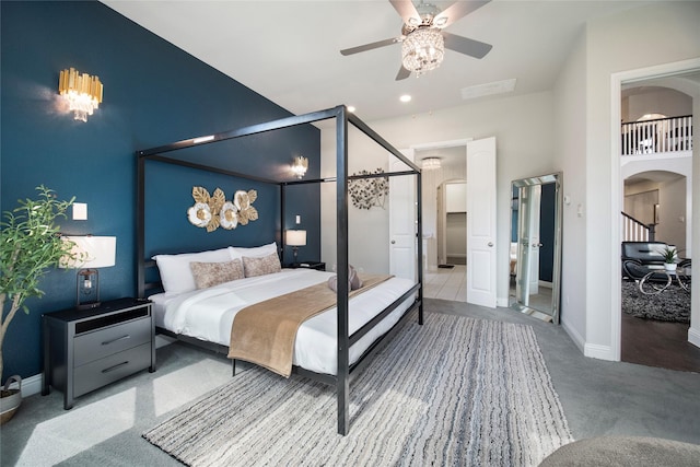 bedroom featuring arched walkways, ceiling fan, and baseboards