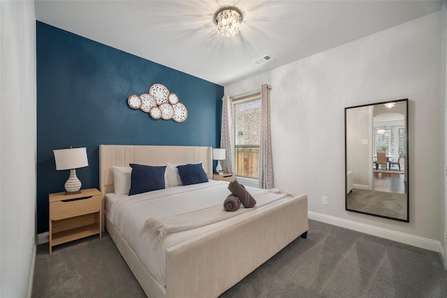 bedroom featuring baseboards, visible vents, dark colored carpet, and a notable chandelier