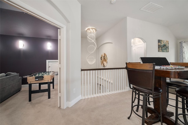 dining space with light carpet, baseboards, visible vents, and a notable chandelier