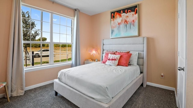 bedroom featuring multiple windows and dark colored carpet