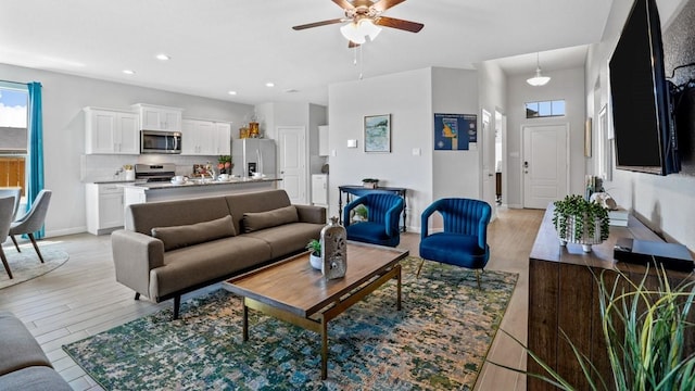 living room with light hardwood / wood-style floors and ceiling fan