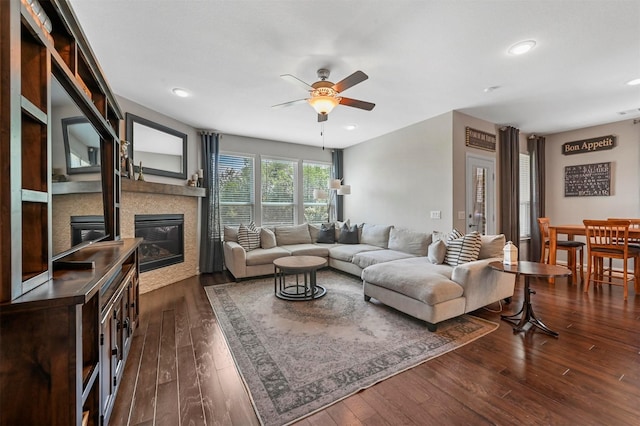 living room featuring ceiling fan and dark hardwood / wood-style flooring