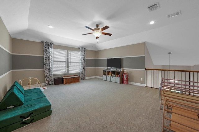 living area featuring ceiling fan, carpet flooring, and vaulted ceiling