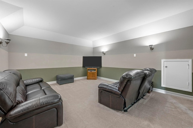 carpeted home theater with vaulted ceiling