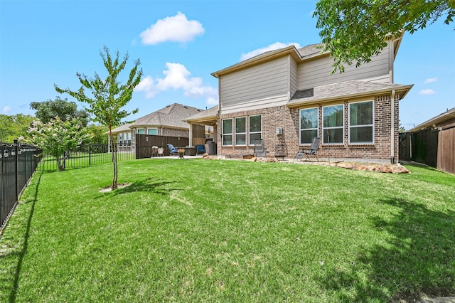 rear view of house featuring a patio area and a yard