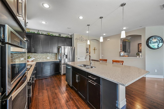 kitchen featuring a kitchen breakfast bar, pendant lighting, a center island with sink, and sink