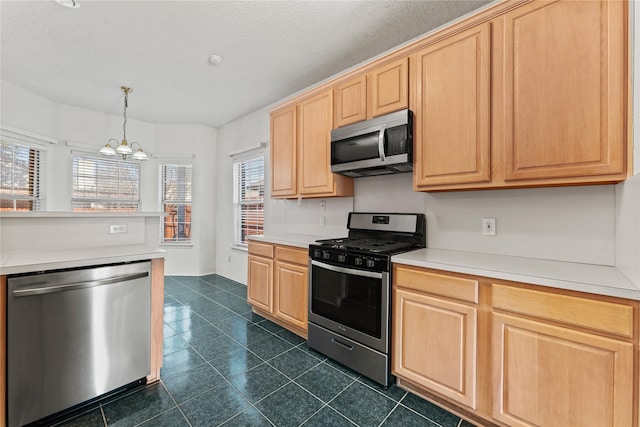 kitchen featuring light brown cabinetry, a notable chandelier, decorative light fixtures, and stainless steel appliances