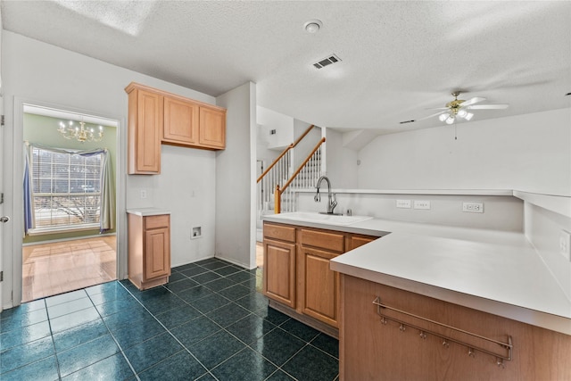 kitchen with ceiling fan with notable chandelier, sink, and a textured ceiling