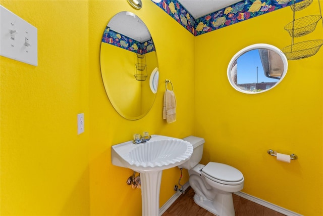 bathroom with hardwood / wood-style flooring and toilet