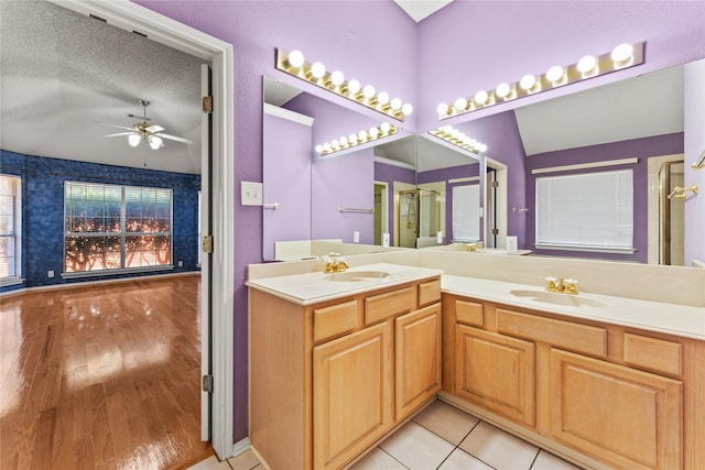 bathroom featuring ceiling fan, vanity, tile patterned flooring, and a textured ceiling