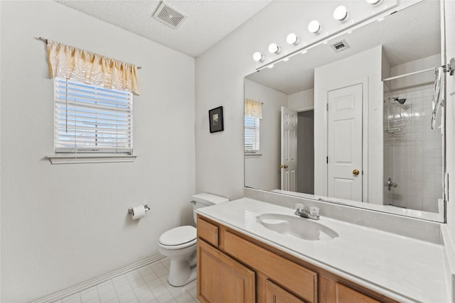 bathroom with vanity, toilet, and a textured ceiling