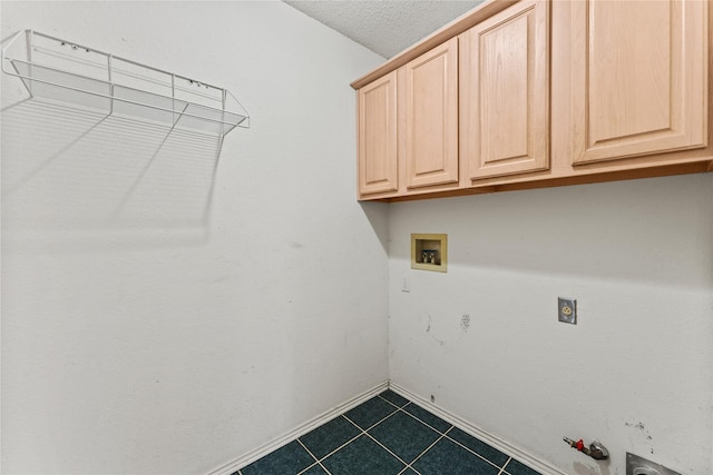 laundry area with gas dryer hookup, cabinets, a textured ceiling, hookup for a washing machine, and electric dryer hookup