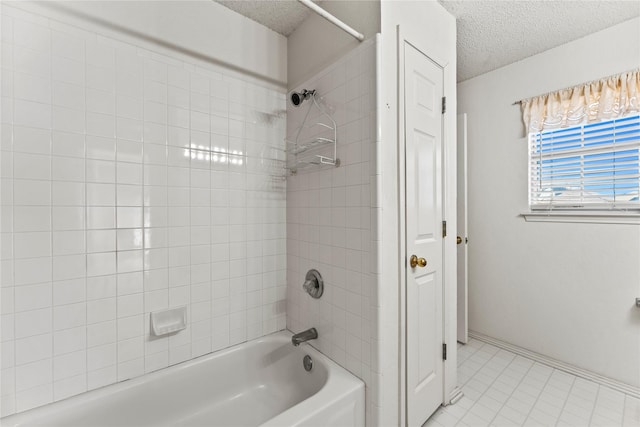 bathroom with tiled shower / bath and a textured ceiling