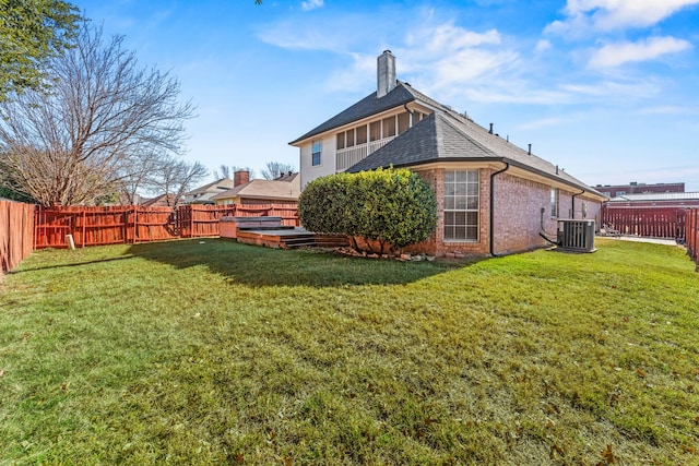 back of property featuring a yard and central AC