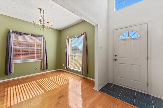 foyer featuring hardwood / wood-style flooring, a textured ceiling, and a chandelier