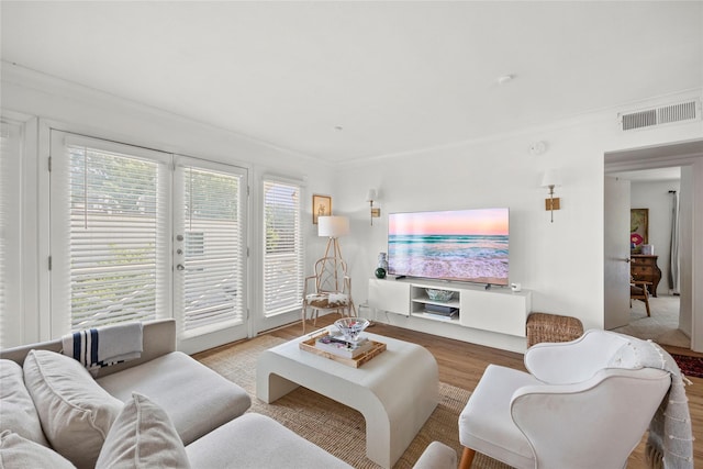 living room with hardwood / wood-style floors and crown molding