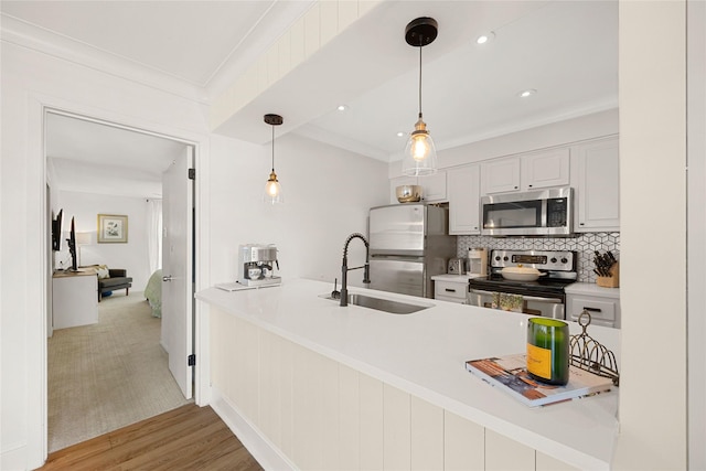 kitchen with white cabinetry, sink, kitchen peninsula, backsplash, and stainless steel appliances