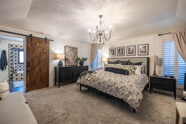 bedroom featuring multiple windows, a barn door, carpet flooring, and a textured ceiling