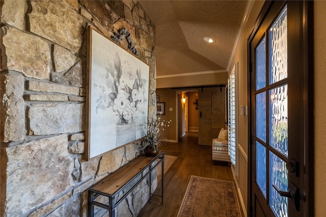 hall with crown molding, vaulted ceiling, a barn door, a textured ceiling, and dark hardwood / wood-style floors