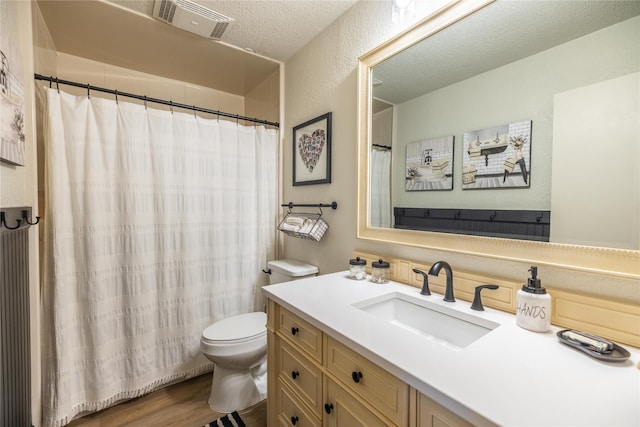 bathroom with vanity, hardwood / wood-style flooring, toilet, and a textured ceiling