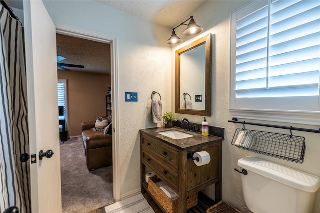 bathroom featuring vanity, a textured ceiling, and toilet