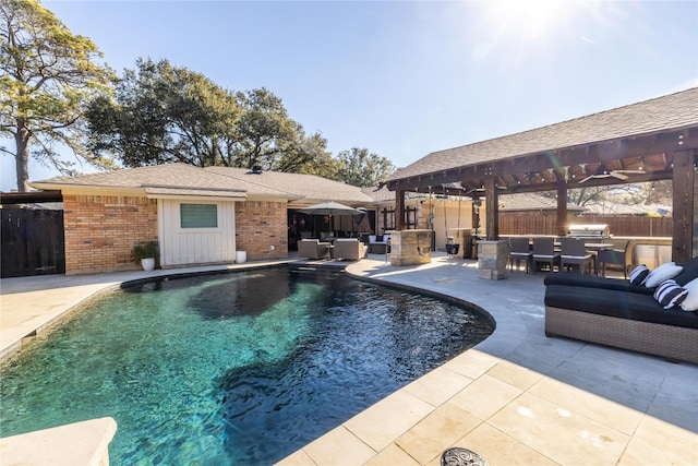 view of pool featuring exterior kitchen, outdoor lounge area, and a patio area