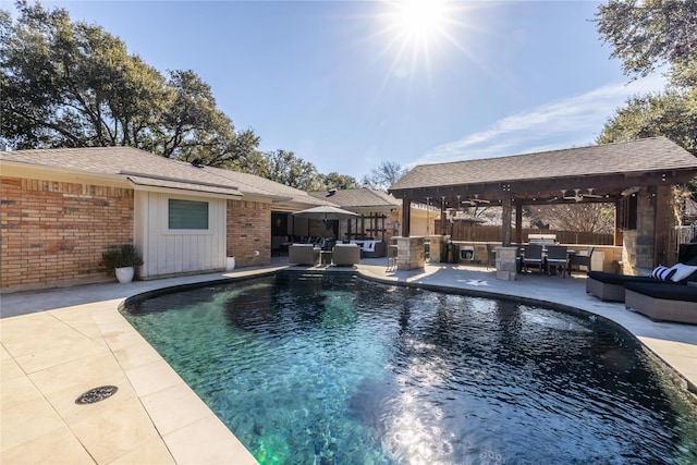 view of pool featuring a gazebo, outdoor lounge area, a patio, and exterior kitchen