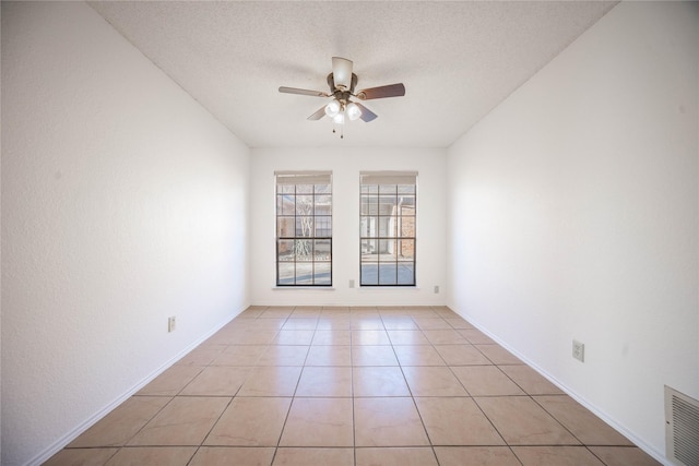 tiled spare room with ceiling fan and a textured ceiling