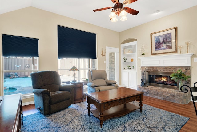 9435 Homestead Ln, Frisco, TX 75033 - living room featuring wood finished floors, built in features, a ceiling fan, and a brick fireplace