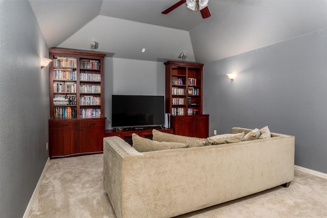 carpeted living room with ceiling fan and vaulted ceiling