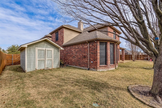 rear view of house with a shed and a yard