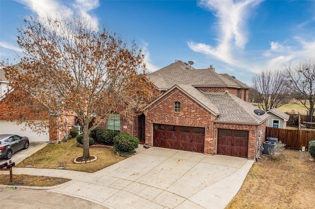 view of front of property with a garage, central AC, and a front yard