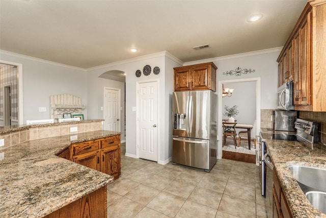 kitchen featuring light tile patterned floors, light stone countertops, appliances with stainless steel finishes, and crown molding