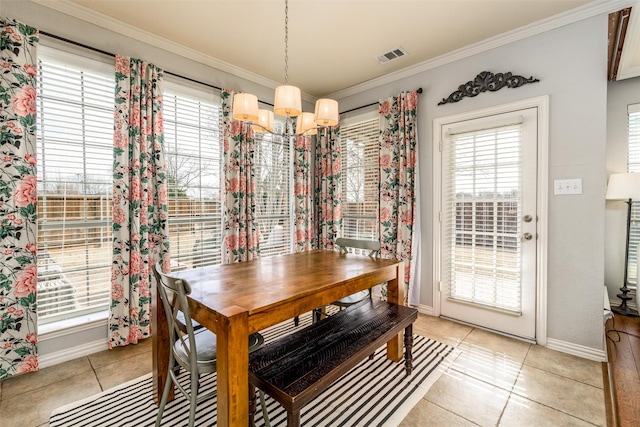 tiled dining space featuring a notable chandelier and ornamental molding