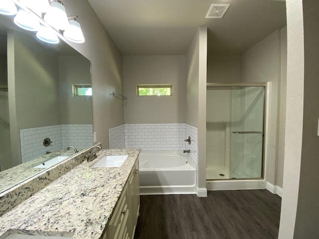 bathroom featuring wood-type flooring, vanity, and plus walk in shower