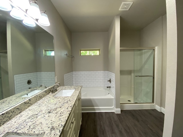 bathroom with hardwood / wood-style floors, vanity, and independent shower and bath