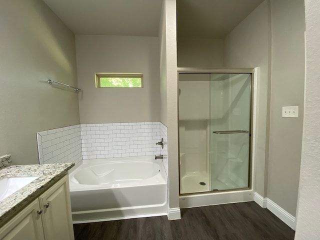 bathroom with vanity, hardwood / wood-style flooring, and plus walk in shower