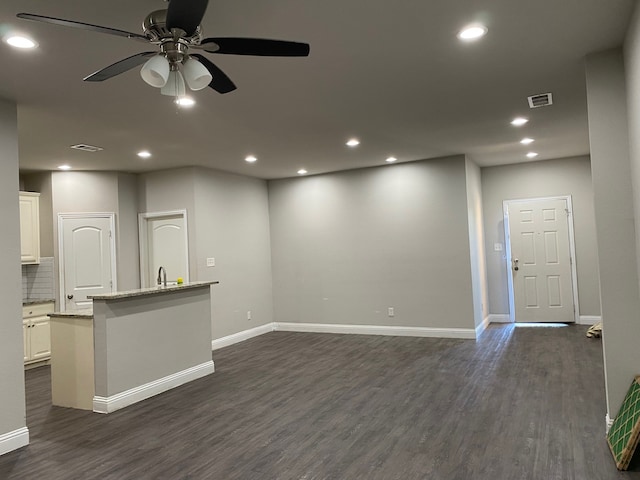 unfurnished living room featuring sink, ceiling fan, and dark hardwood / wood-style flooring