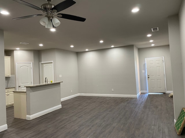 unfurnished living room with ceiling fan, sink, and dark hardwood / wood-style floors