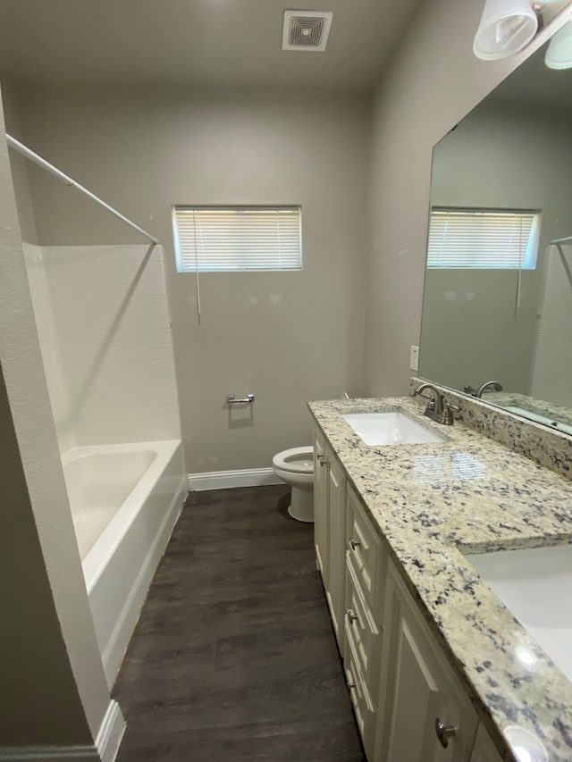 full bathroom with vanity, hardwood / wood-style flooring,  shower combination, and toilet