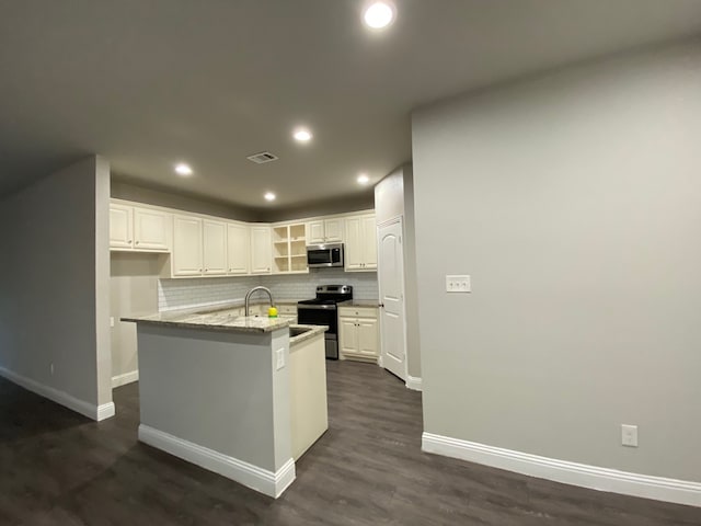 kitchen with white cabinets, dark hardwood / wood-style floors, light stone countertops, and appliances with stainless steel finishes