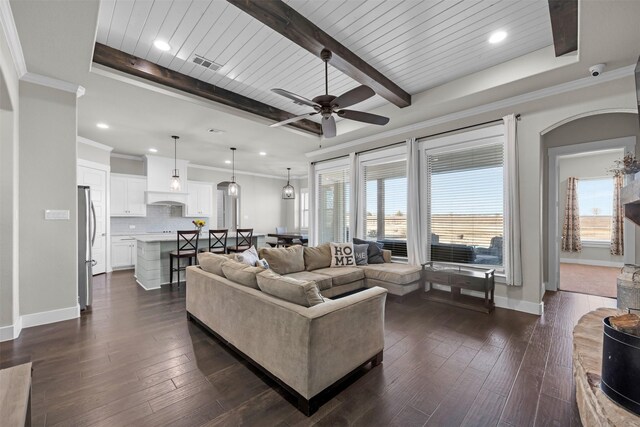 living room featuring dark hardwood / wood-style flooring, a stone fireplace, ornamental molding, a raised ceiling, and wooden ceiling