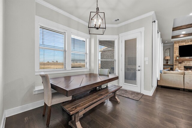 kitchen featuring decorative light fixtures, white cabinetry, light stone countertops, and an island with sink